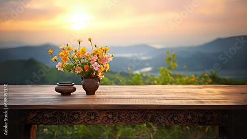 A large wooden table (with space to put things) sits in a field of flowers. overlooking the mountain scene golden rays of sunrise (There is space for writing text), Generative AI photo