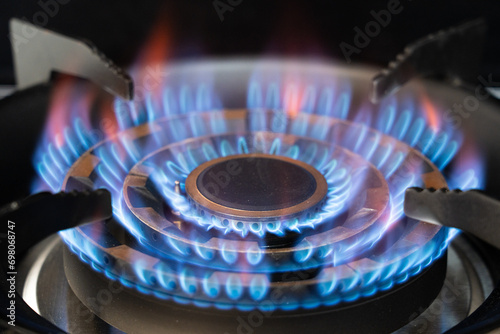 Gas burner with blue burnig methane flame on black background photo