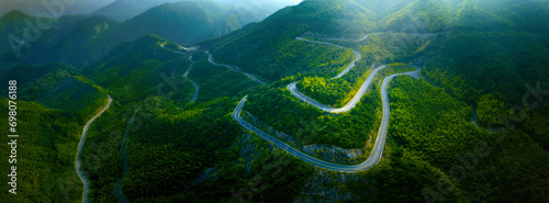 Top view from drone of mountain road in woods in a summer day. © powerstock
