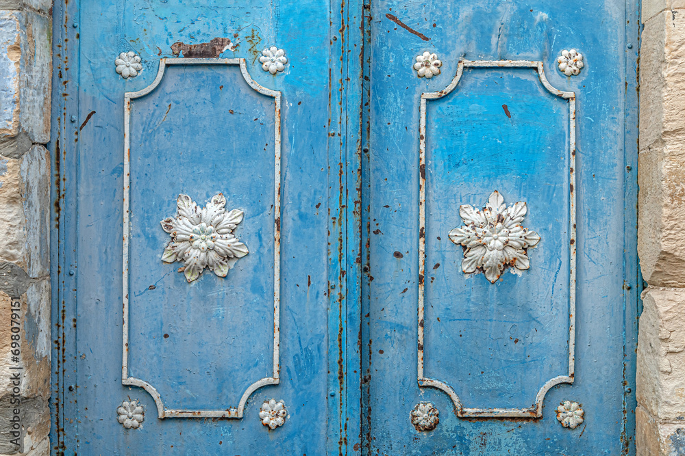 abstract background of old metal doors painted blue with beatiful floral decor close up abstract background of old metal doors painted blue with beatiful floral decor close up