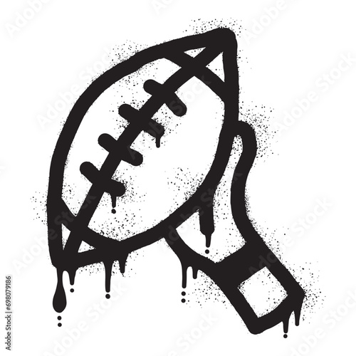 Graffiti of hands holding an American football ball with black spray paint