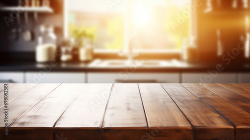 An empty wooden table provides a natural, rustic surface with a bright, blurred kitchen background, suggestive of a cozy home environment. photo