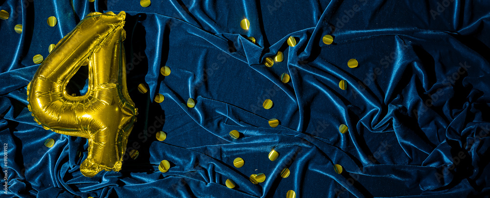 Gold foil balloon number four on blue velvet. Birthday greeting card with inscription 4. Golden numeral and fabric background. Numerical digit with glitter. Banner. Gold foil balloon number four on blue velvet. Birthday greeting card with inscription 4. Golden numeral and fabric background. Numerical digit with glitter. Banner.