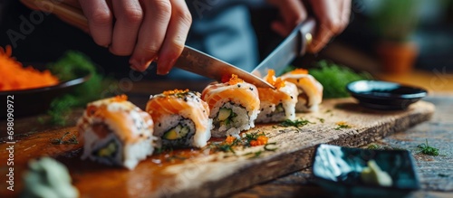 Person grips sushi with knife.