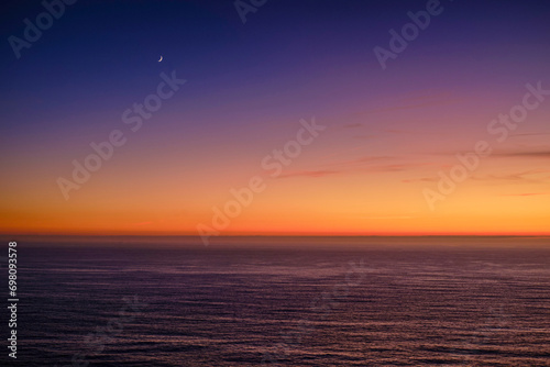 Obraz na płótnie Serene summer sunset over sea waters and crescent moon in the sky. w salonie