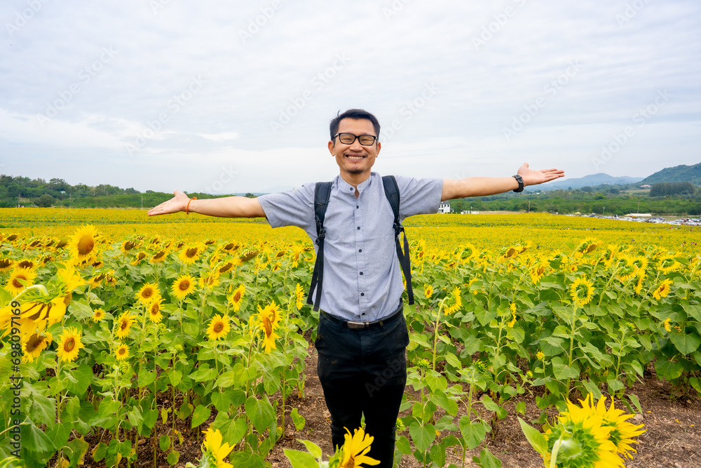 Alone man tourist travel in sunflower garden on hill of countryside