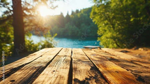 Empty wooden table top with blurred nature background. Calm sunny day, evening in nature with view to lake, river water and forest, park trees. Table top with copy space for product advertising