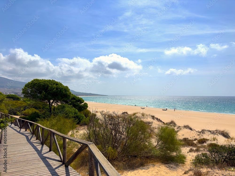 view from a wooden walkway to the beautiful beach and dunes at the Playa de Bolonia at the Costa de la Luz, Andalusia, Cadiz, Spain