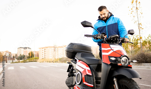Mobile application for renting electric motorcycles. Rent electronic scooters to explore the city. Concept of renting electric vehicles by the minute. An adult man is renting an electric motorcycle.