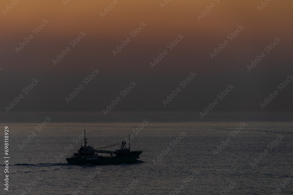 朝焼けの始まる頃の海をゆく船20231121 - obrazy, fototapety, plakaty 