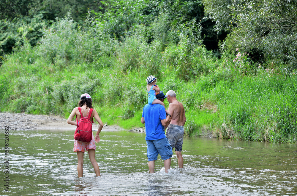 Shallow river and tourists going for a picnic on the beach by the river
