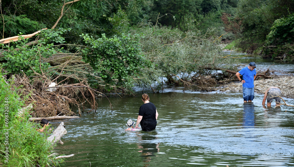 The whole family crosses the shallow river for a picnic on the river bank
