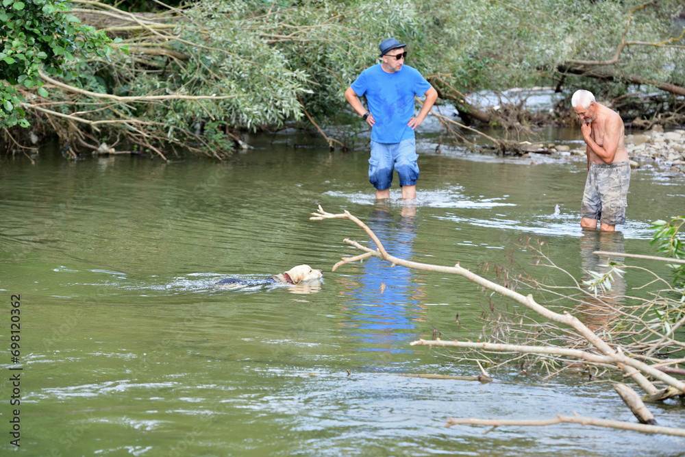 Shallow river and tourists going for a picnic on the beach by the river