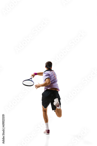 Man, tennis player in motion during game, training, hitting ball with racket isolated over white background. Concept of professional sport, movement, competition, action. Ad © master1305