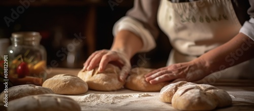Professional baker woman preparing dough for bread such as sourdough or artisan bread on kitchen table