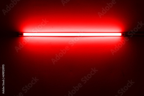 Red neon lamp on a white wall for design