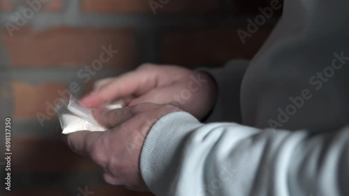 A drug dealer holds a bag of cocaine in his hand. Heroin drug addiction concept. photo