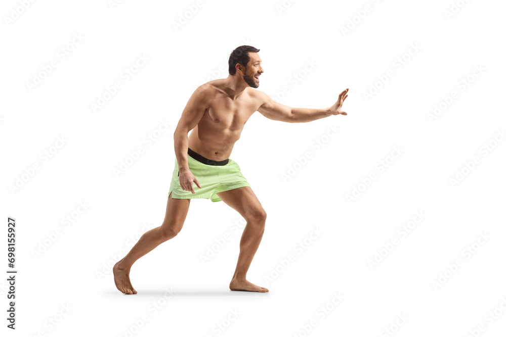 Young man in swimming shorts waiting to catch something Young man in swimming shorts waiting to catch something