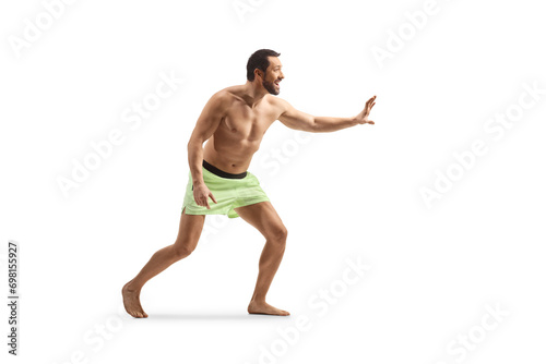 Young man in swimming shorts waiting to catch something