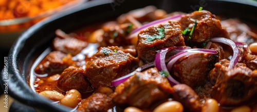 Mexican pork stew marinated with achiote, often served with beans and spicy red onion. photo