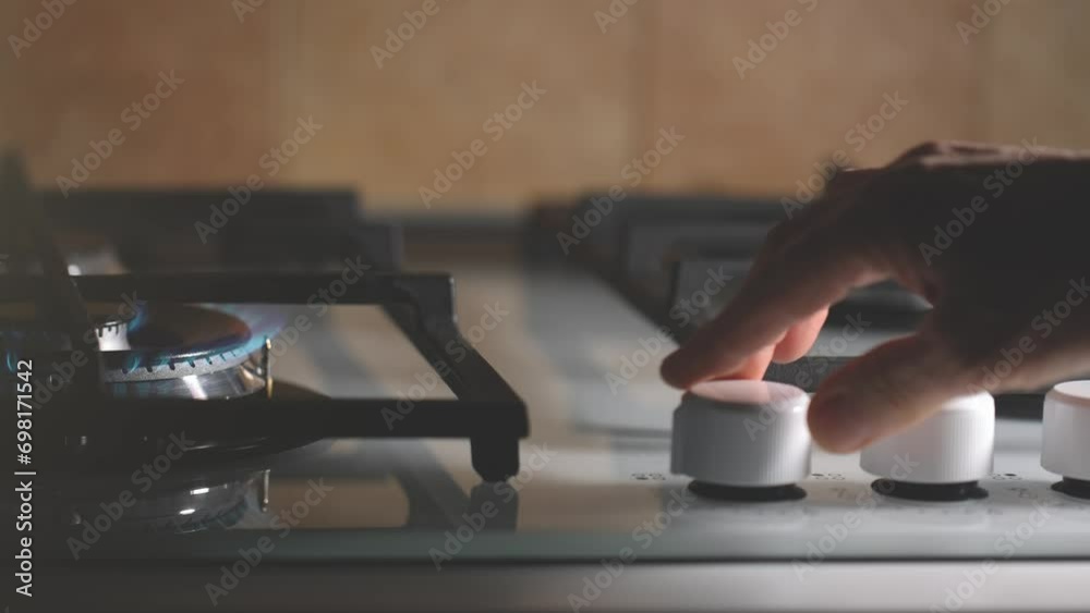 Closeup of a man lighting the gas burner to cook in the kitchen. Switch on the gas stove to prepare food.