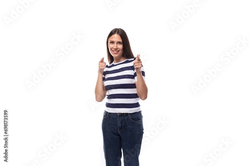 cute young european woman with black straight hair wears striped black and white t-shirt and jeans in summer. people clothes concept