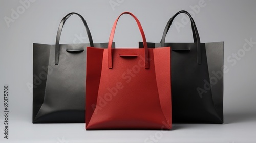 3 paper shopping bagd, black and red colors, on solid gray background