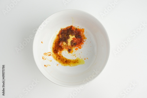 White ceramic bowl only containt of spices of instant noodle inside. White background. photo