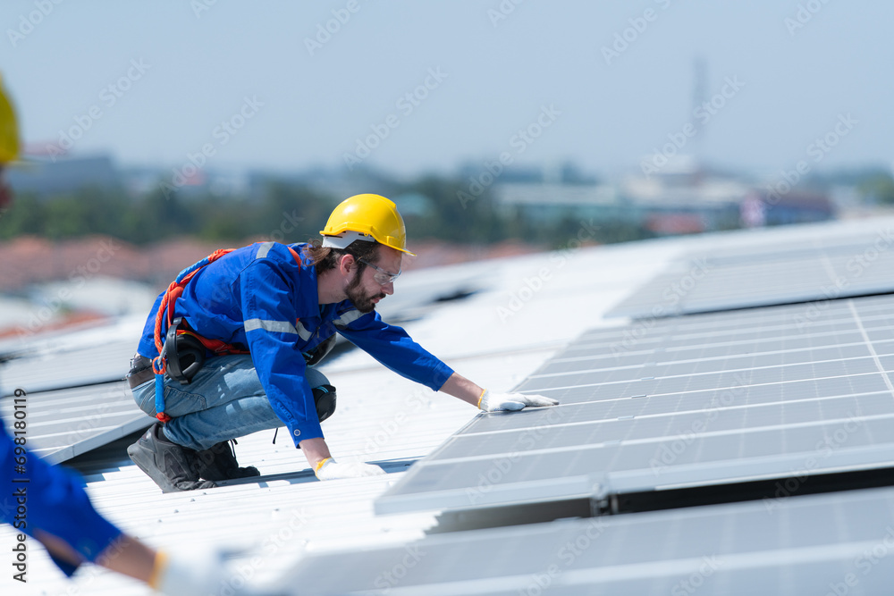 Both of technicians is installing solar panels on the roof of the warehouse to change solar energy into electrical energy for use in factories. Both of technicians is installing solar panels on the roof of the warehouse to change solar energy into electrical energy for use in factories.