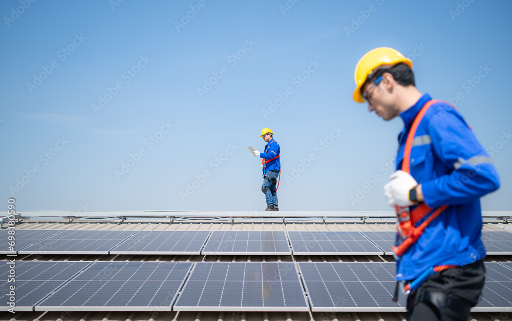 Both of technicians is installing solar panels on the roof of the warehouse to change solar energy into electrical energy for use in factories. Both of technicians is installing solar panels on the roof of the warehouse to change solar energy into electrical energy for use in factories.