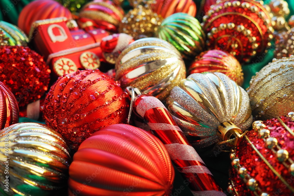 New Year's Christmas balls, tinsel and decorations close up. A lot of decoration of golden, red, yellow, green. Striped Christmas balls. Festive beautiful colorful background. Home holidays design.