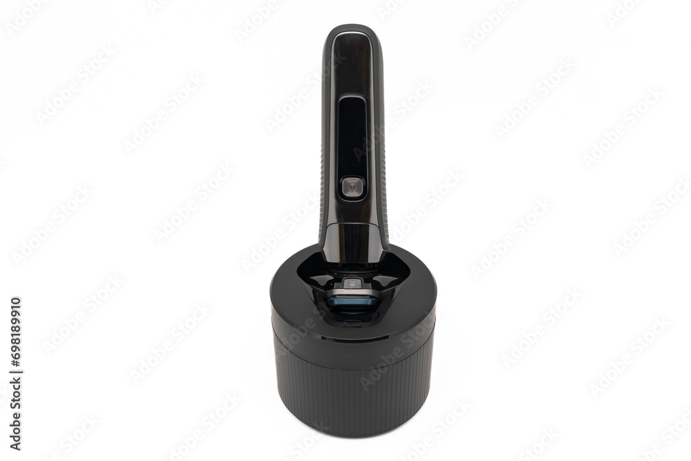 Electric shave machine for men on the cleaning pod or cleaning station, isolated on white with copy space. Electric shaver. Electric shave machine for men on the cleaning pod or cleaning station, isolated on white with copy space. Electric shaver.