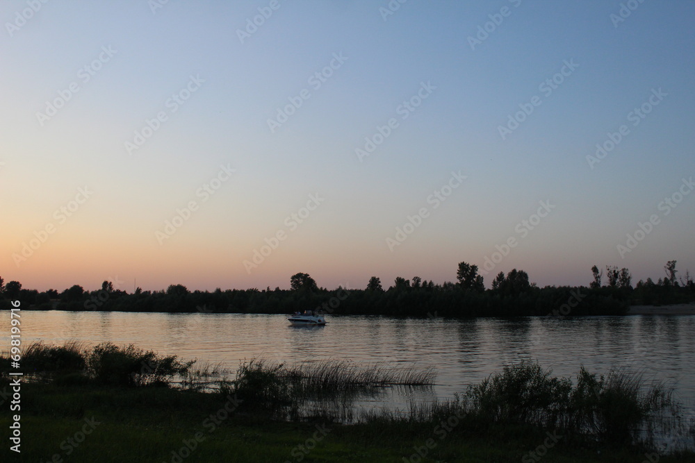 Sunset over the river red and blue sky over the river in the evening with black dark bank