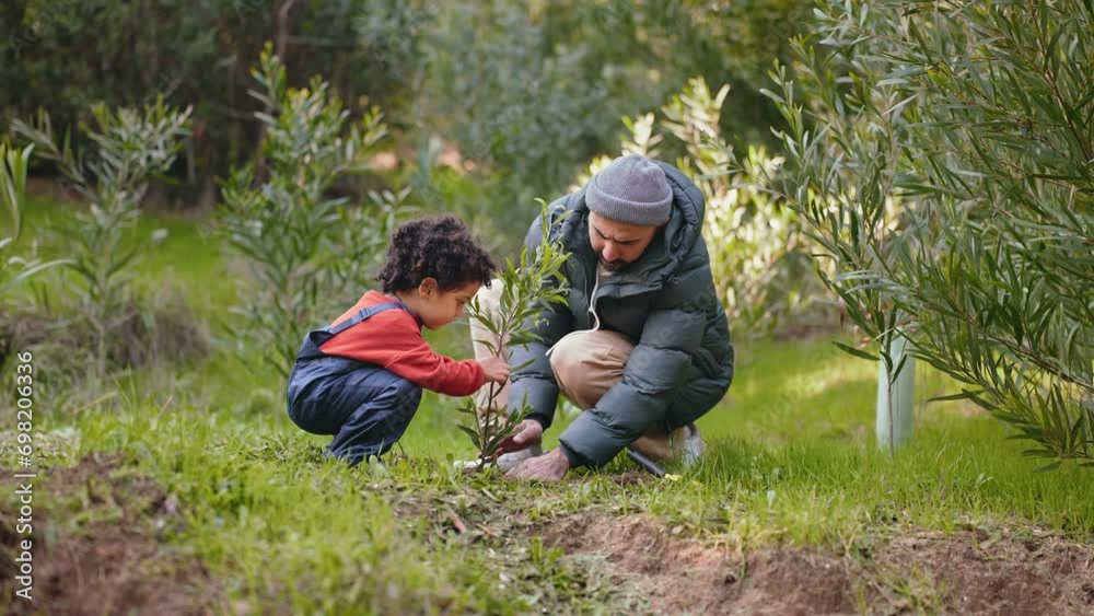 Adorable scene of a little boy joyfully assisting his father in planting a tree. A heartwarming family moment of environmental care and bonding Adorable scene of a little boy joyfully assisting his father in planting a tree. A heartwarming family moment of environmental care and bonding