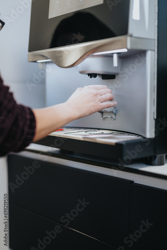Close up shot of female person taking a coffee from the coffee maker.