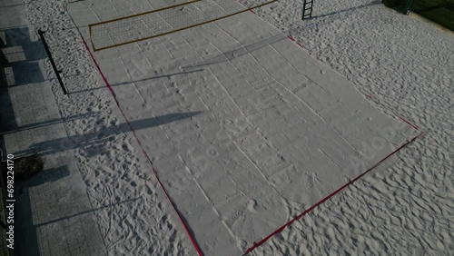 white sand beach volleyball court. white soft dunes fenced with nets. The lines of the playing field are made of blue textile plastic straps photo