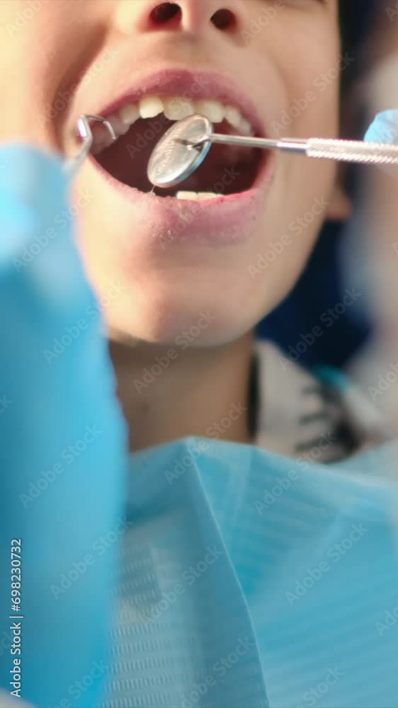 While assessing a young patient for tooth decay, a compassionate female dentist employs a dental probe and angled mirror. While assessing a young patient for tooth decay, a compassionate female dentist employs a dental probe and angled mirror.
