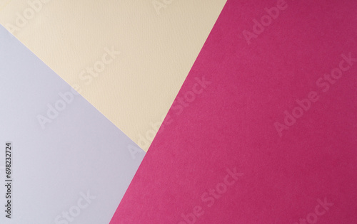 Multi colored abstract paper of pastel gray,yellow,magenta colors palette, with geometric shape, flat lay.