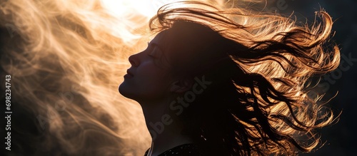Backlit silhouette of woman's hair in motion. photo