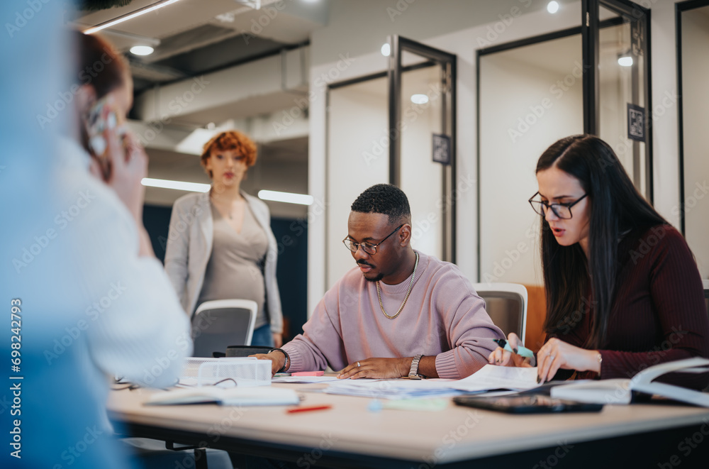 Obraz premium Diverse business team working on successful project completion in office.