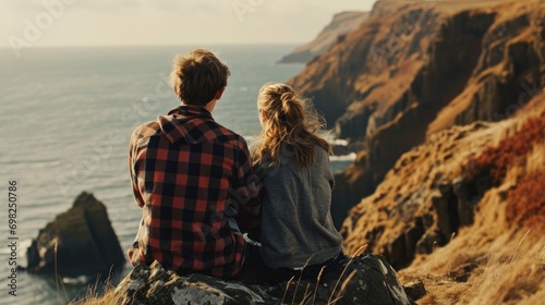 Young couple sitting near sea cliffs and enjoying the view