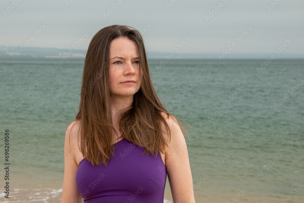 Portrait of a beautiful young woman with long brown hair on the beach