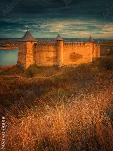 portrait view to fortress in golden light with dried grass on foreground