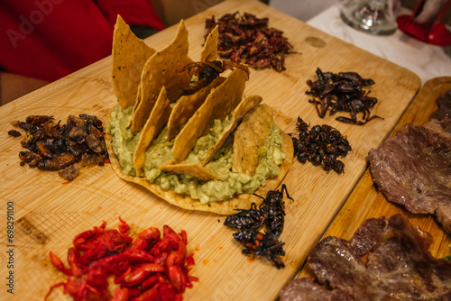 Delicious insect board with guacamole and toast, with grasshoppers, chinicuiles, escamoles, chicatanas, acosiles, scorpions. Traditional pre-Hispanic Mexican food. photo