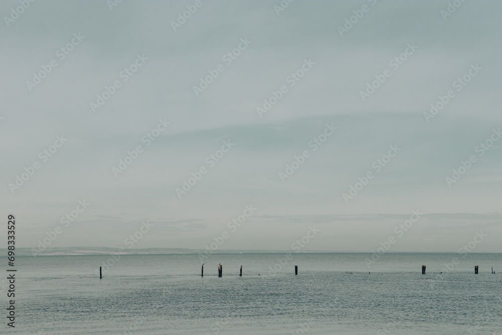 misty sea landscape with remains of old pier