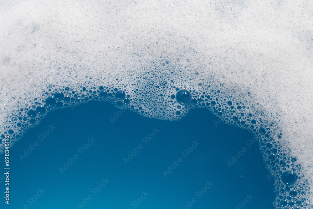 Detergent foam bubble on wate. Blue background, Soap sud - obrazy, fototapety, plakaty 