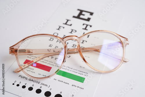 Glasses on eye exam chart to test eyesight accuracy of reading.