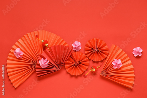 Fans with beautiful flowers and lanterns on red background. Chinese New Year celebration