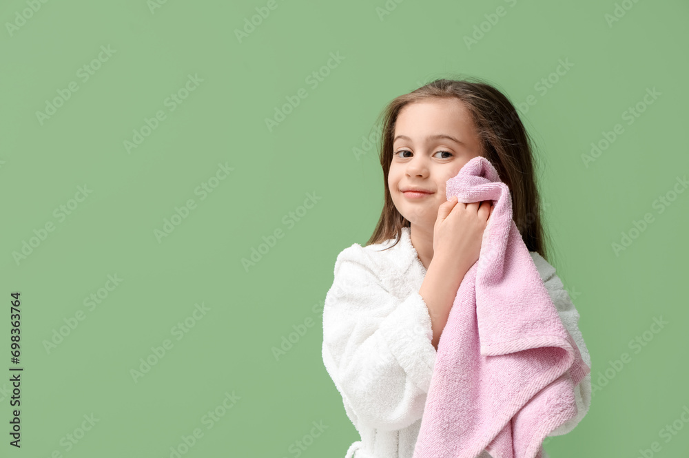 Cute little girl in bathrobe with towel on green background Cute little girl in bathrobe with towel on green background