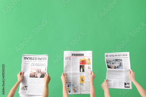 Women with newspapers on green background photo